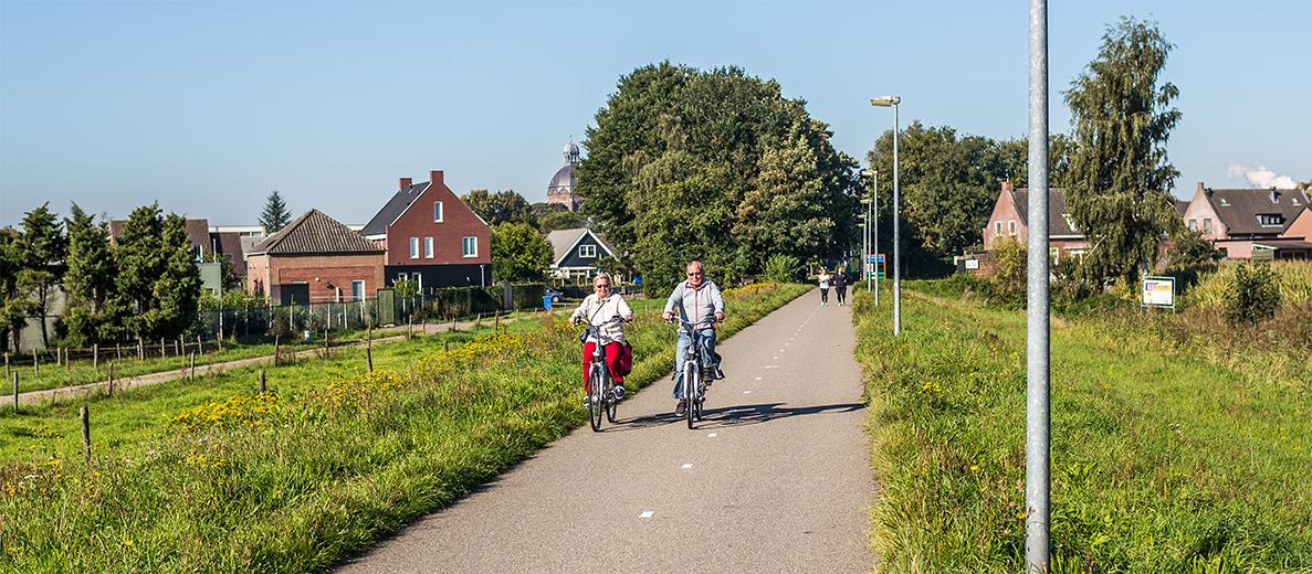 foto van fietsende mensen op een dijkje