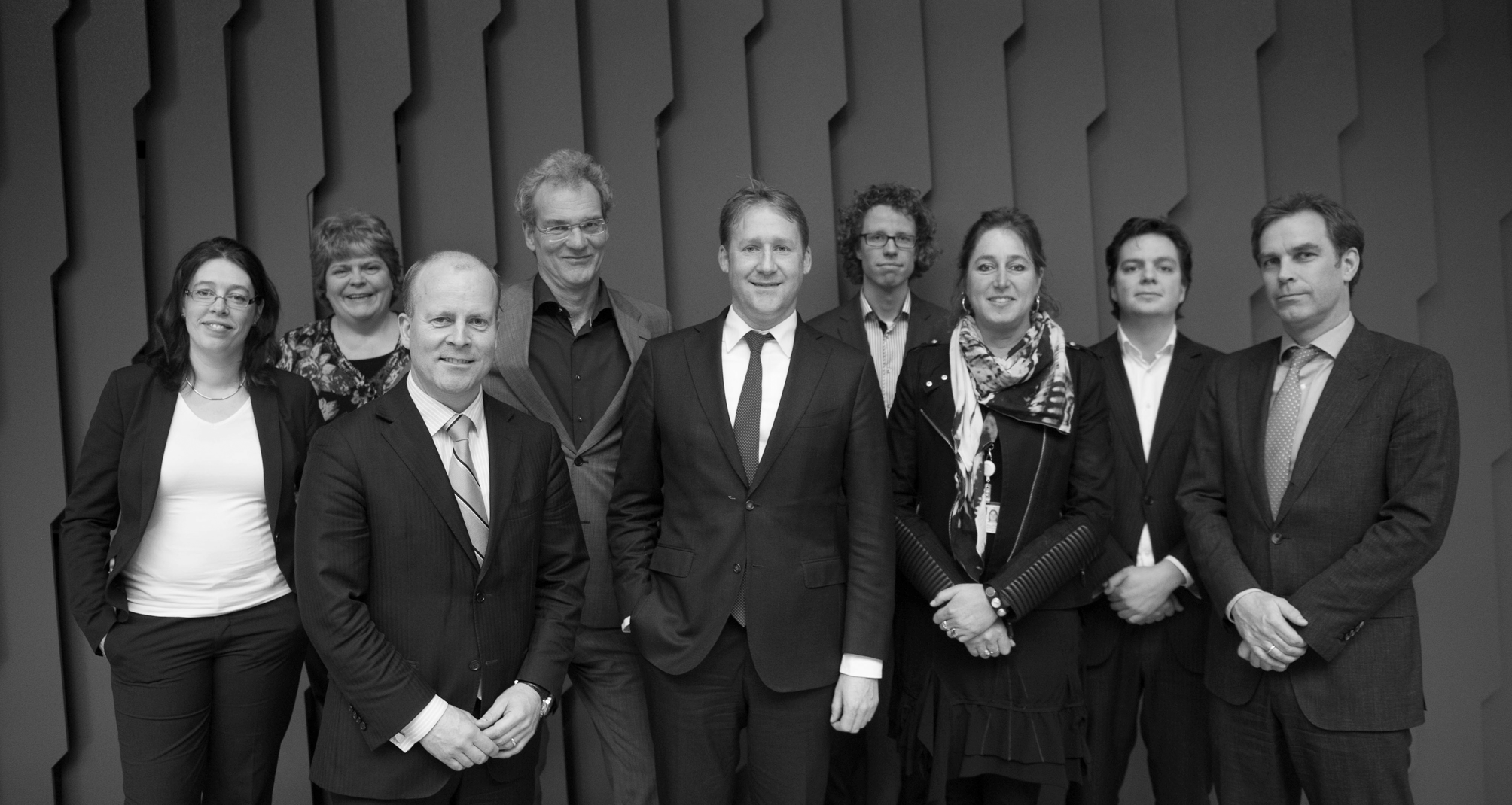 Van links naar rechts de staf van de tijdelijke commissie Huizenprijzen: L.K. Middelhoven, B. van Leeuwen, M.J.H. Balster, J. Thomassen, M.J. van der Leeden. Op de voorgrond de leden van de commissie.